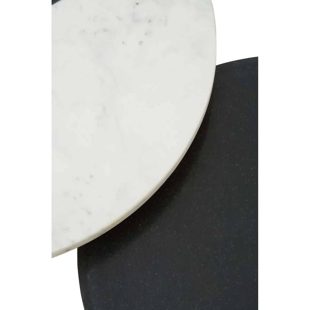 Closeup of round marble coffee table with white and black tabletops overlapping