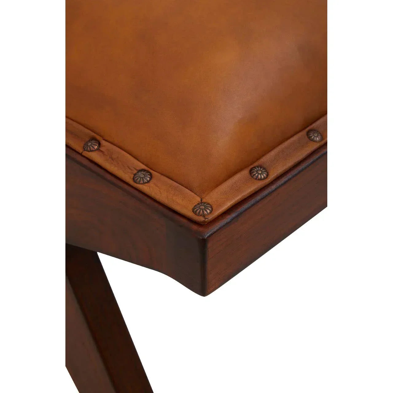 Close-up of brown leather seat cushion with button detail on wooden bench corner