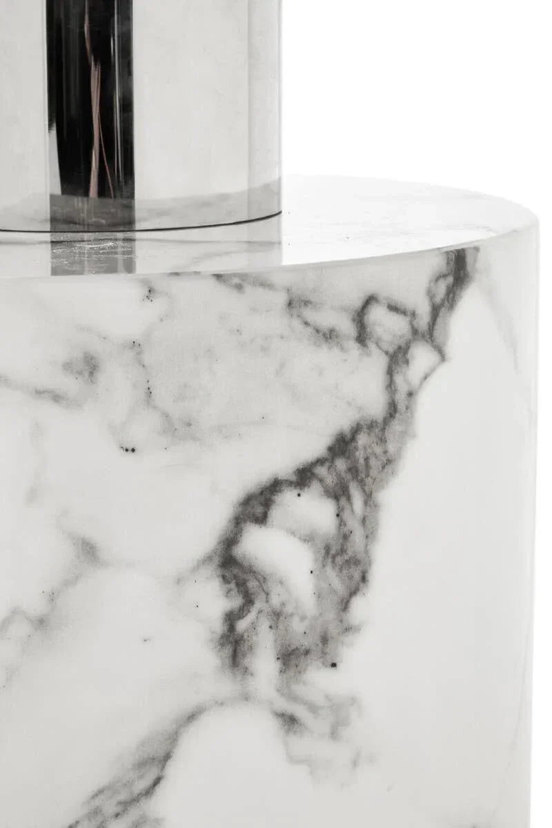 Close-up of round marble coffee table with polished metal accent and grey veining