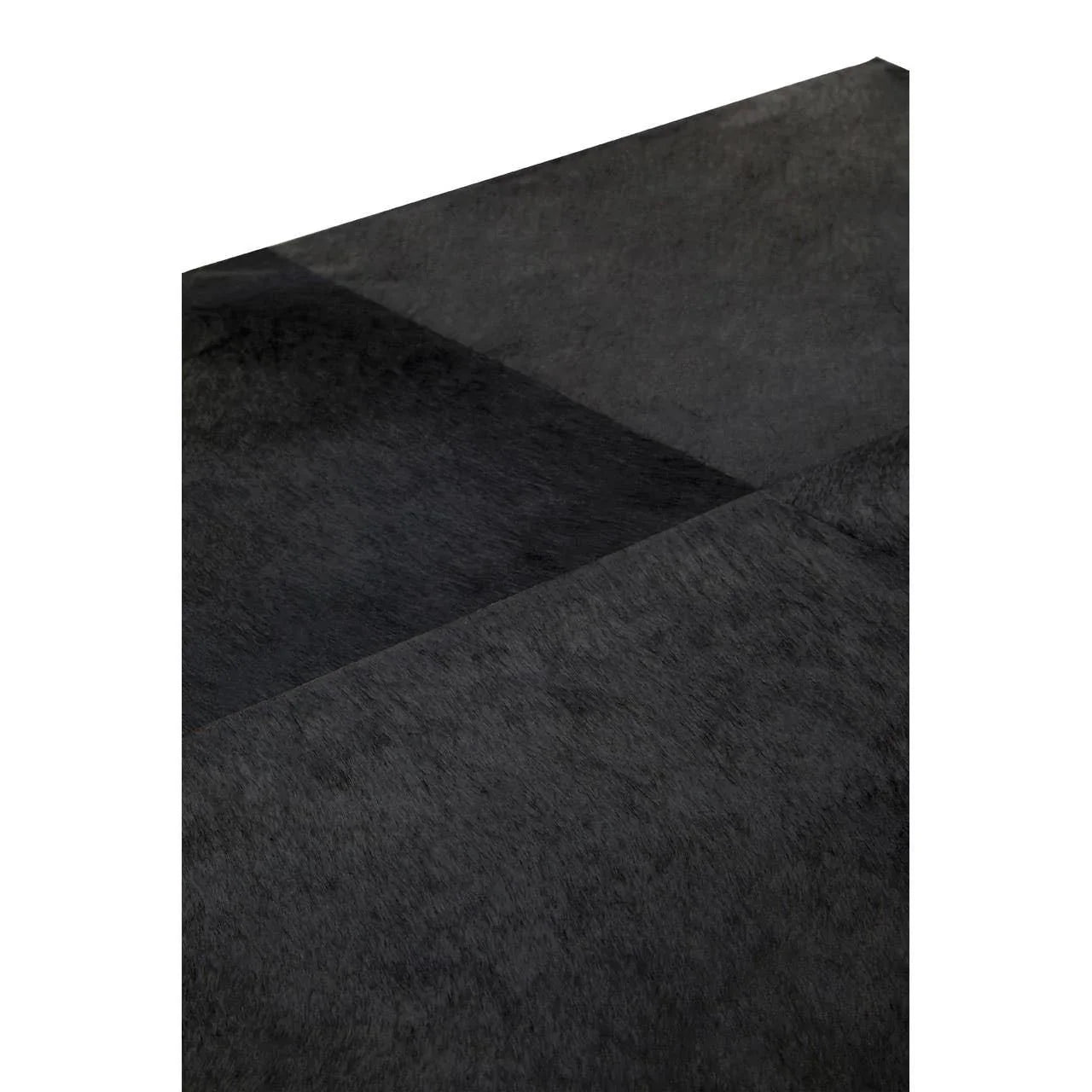 Close-up of black patchwork rug with textured square panels