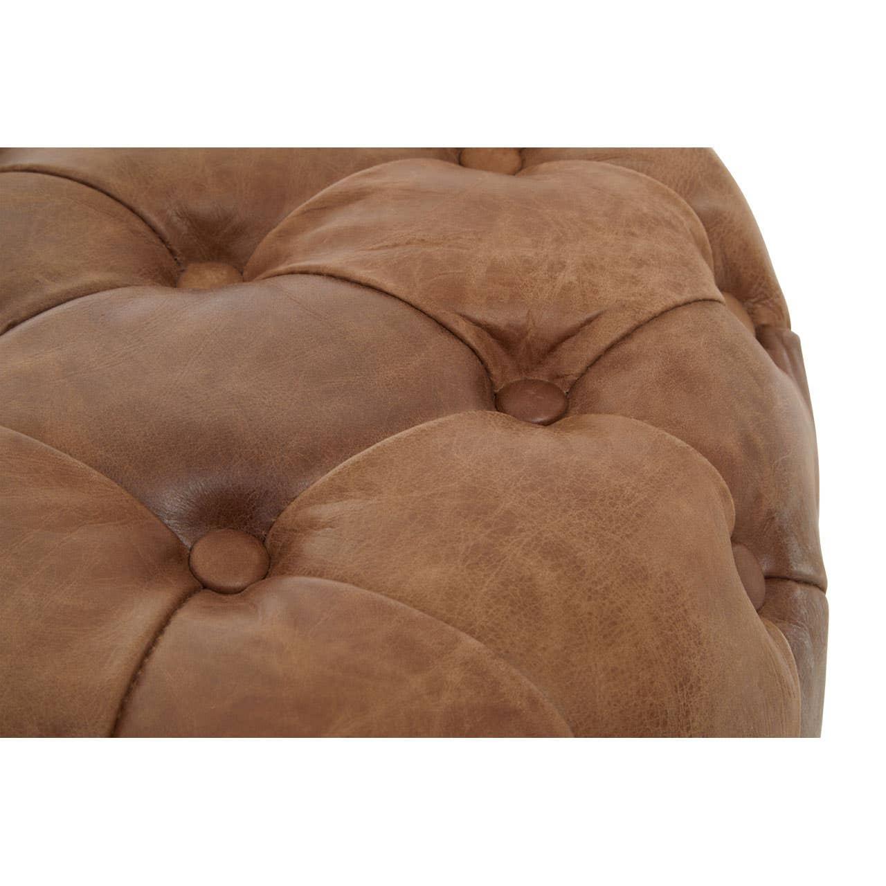 Close-up of brown leather ottoman with deep button tufted upholstery