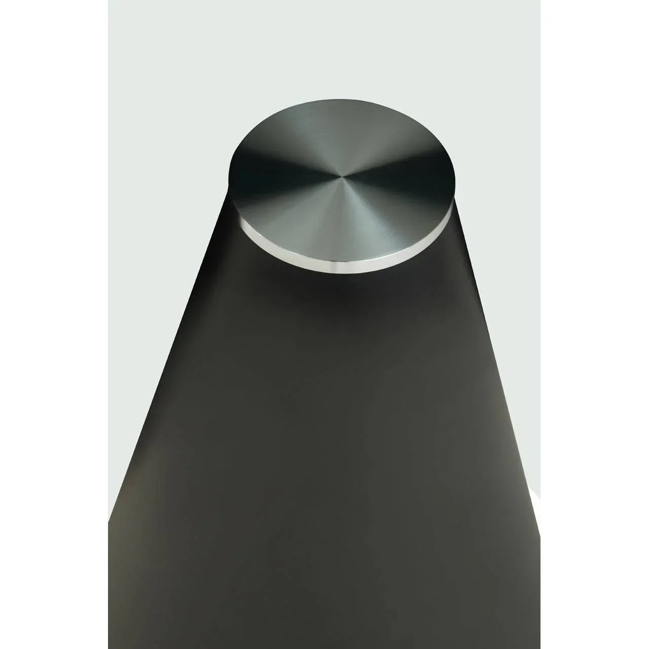 Brushed metal table leg with circular top and matte black finish, angled overhead view