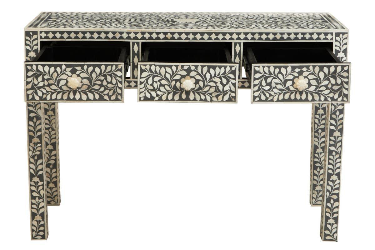 Black and white inlay console table with floral pattern and three open drawers