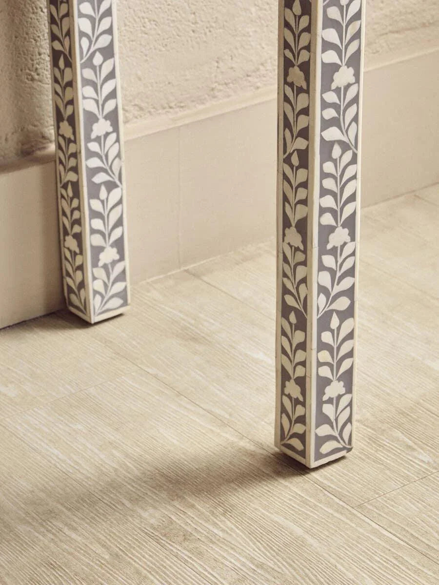 Bone inlay table legs with floral pattern on light wood floor