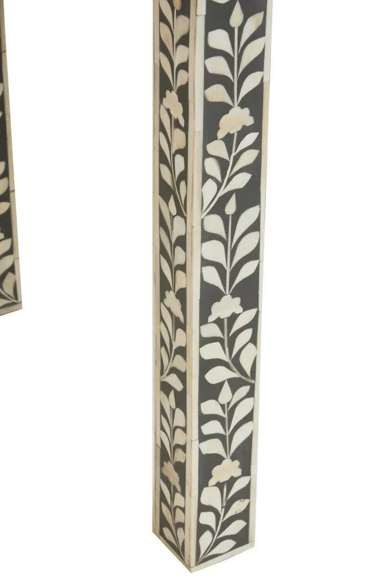 Table leg with black and white floral inlay pattern, close-up showing decorative detail
