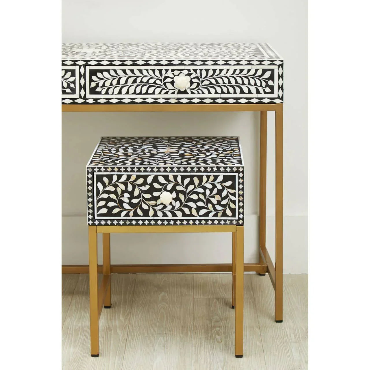 Black and white inlay console table and matching side table with gold legs on wood floor