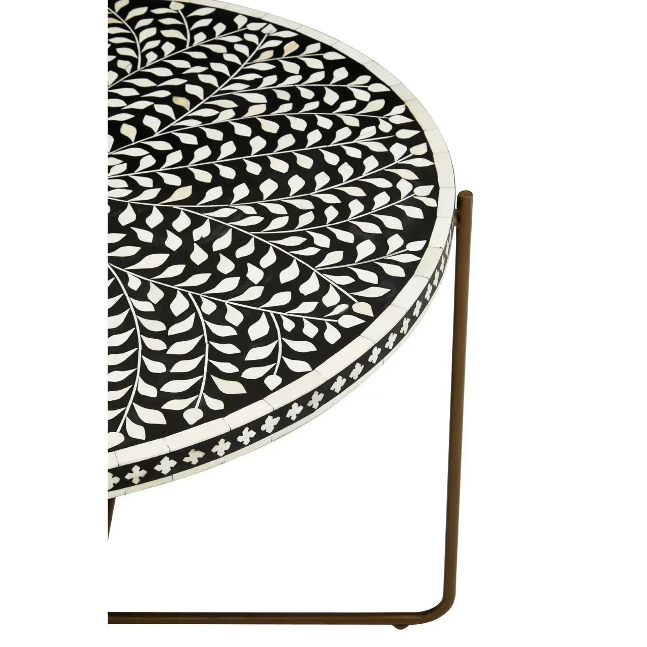 round side table with black and white leaf pattern top and slim metal legs