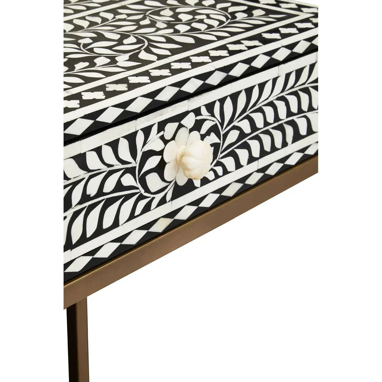 Black and white bone inlay console table with floral detail and brass legs, close-up view