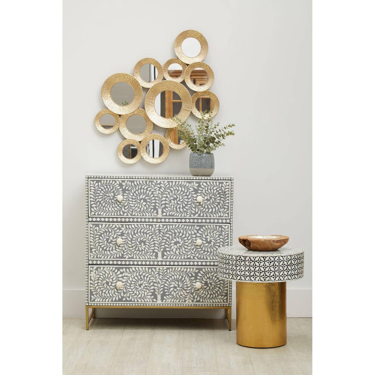 Bone inlay chest of drawers with floral pattern, gold accent side table, round wall mirrors