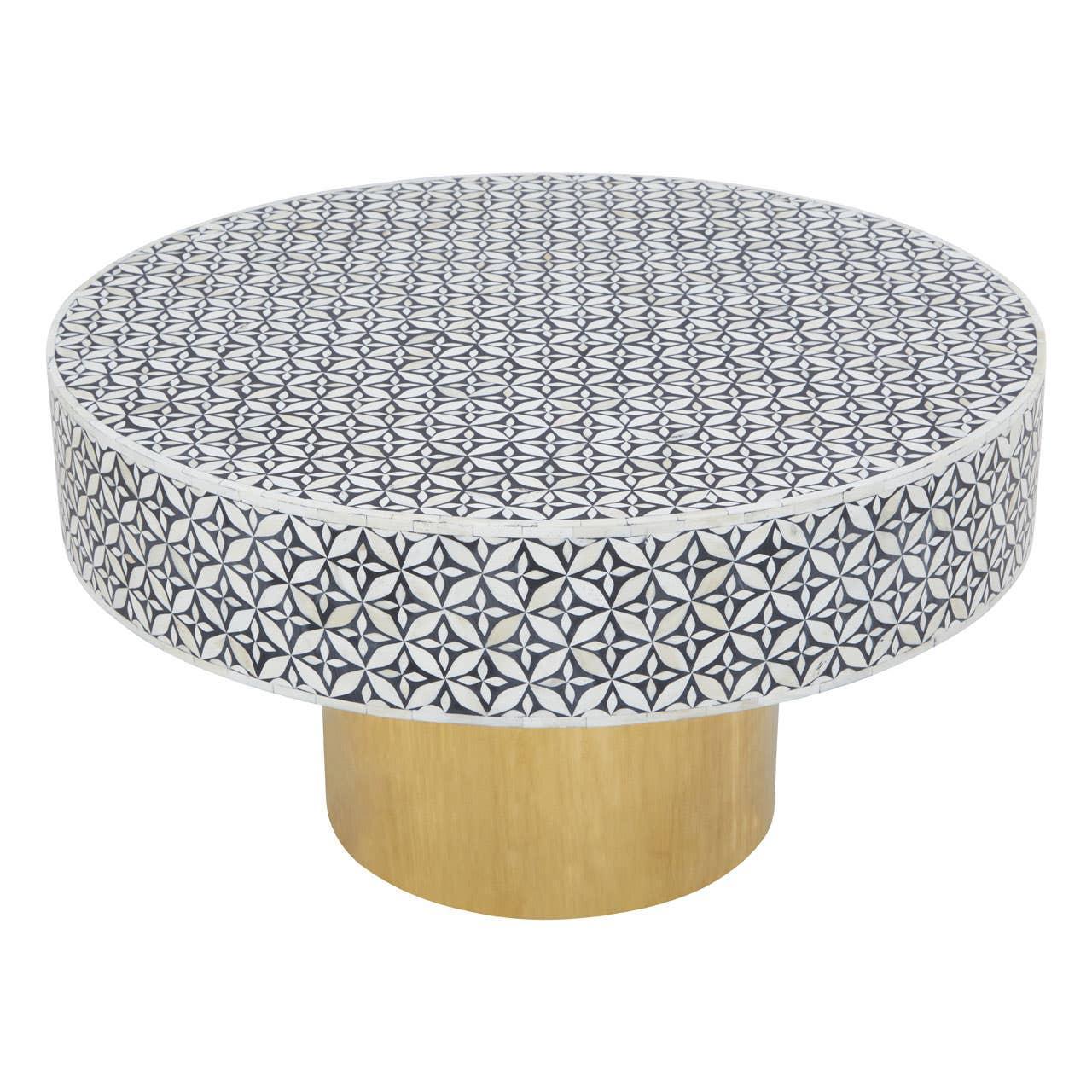 Round coffee table with black and white geometric patterned top and gold cylindrical base