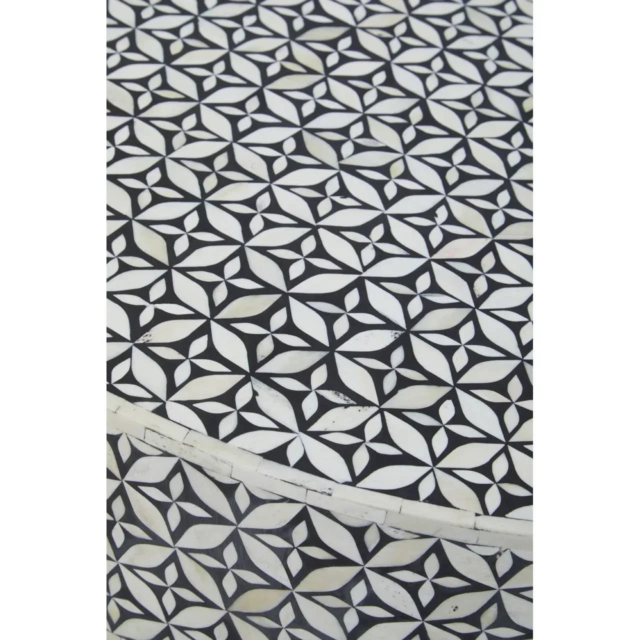 Closeup of black and white geometric patterned table with inlaid bone detailing