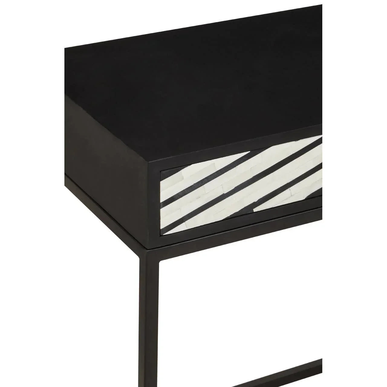 Black console table with diagonal white inlay drawer detail and metal frame, close-up view
