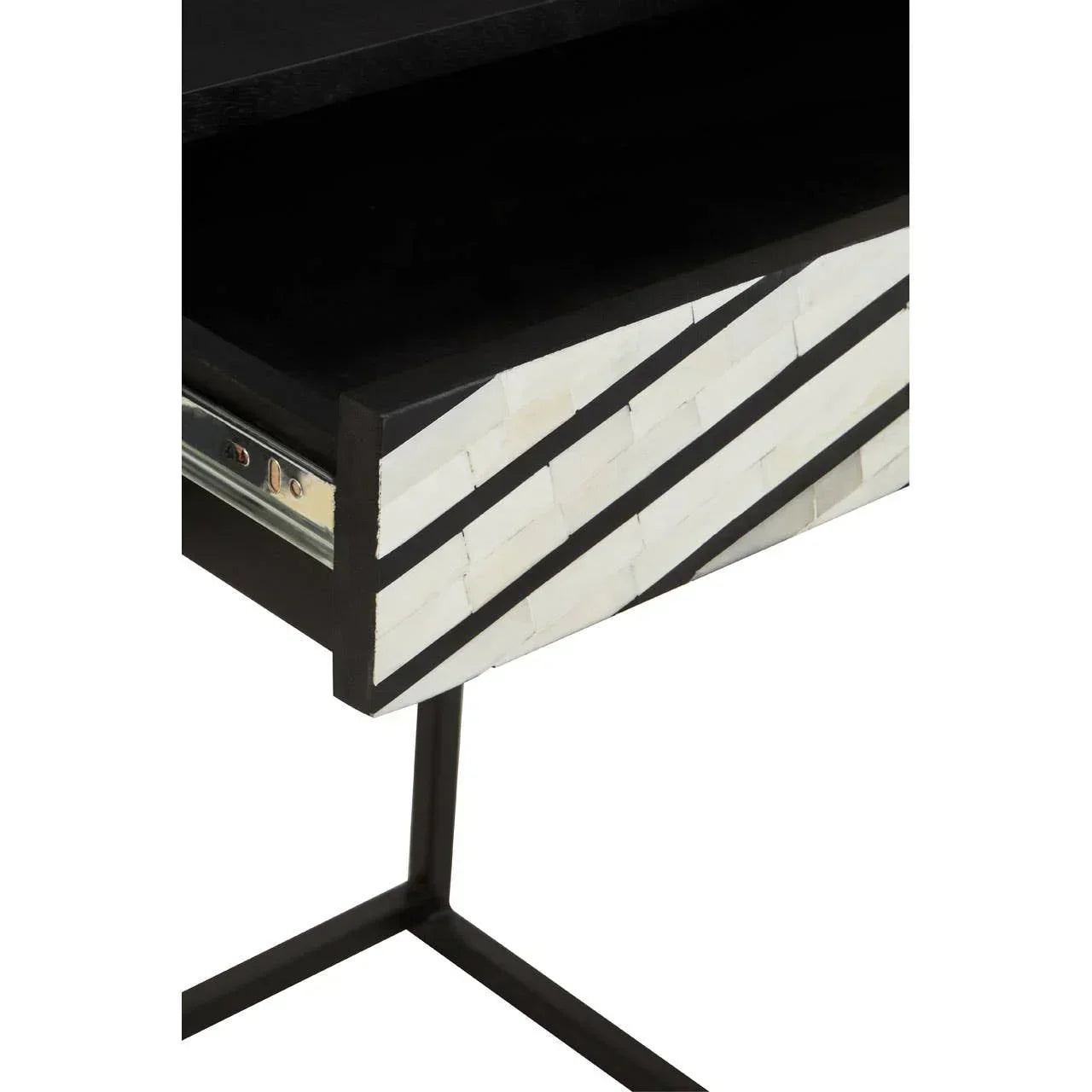 Black metal console table drawer with white geometric inlay front, close-up view