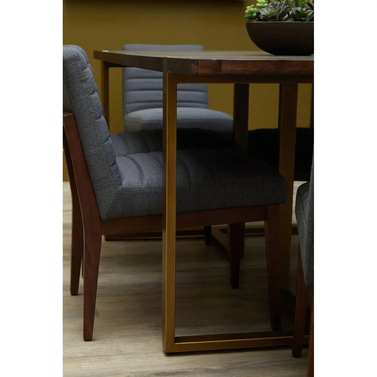 Grey upholstered dining chairs with wooden legs at modern dining table