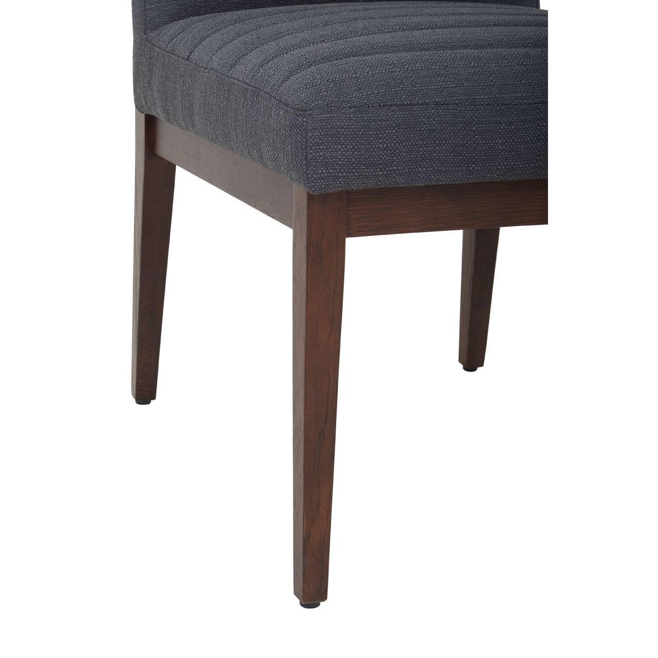 Dark grey upholstered dining chair seat with wooden legs, close side angle view