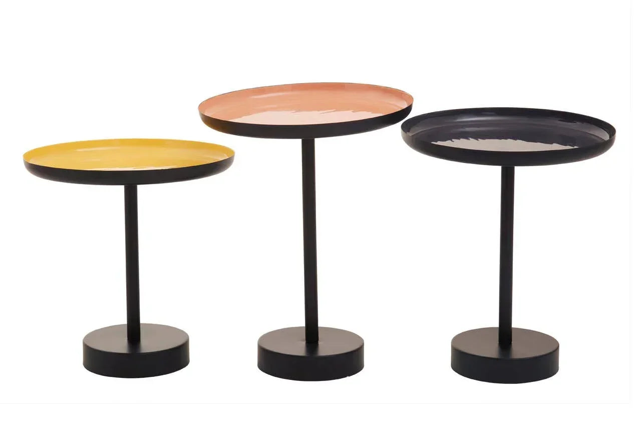 Set of three round metal side tables with yellow, peach, and black tops and black bases