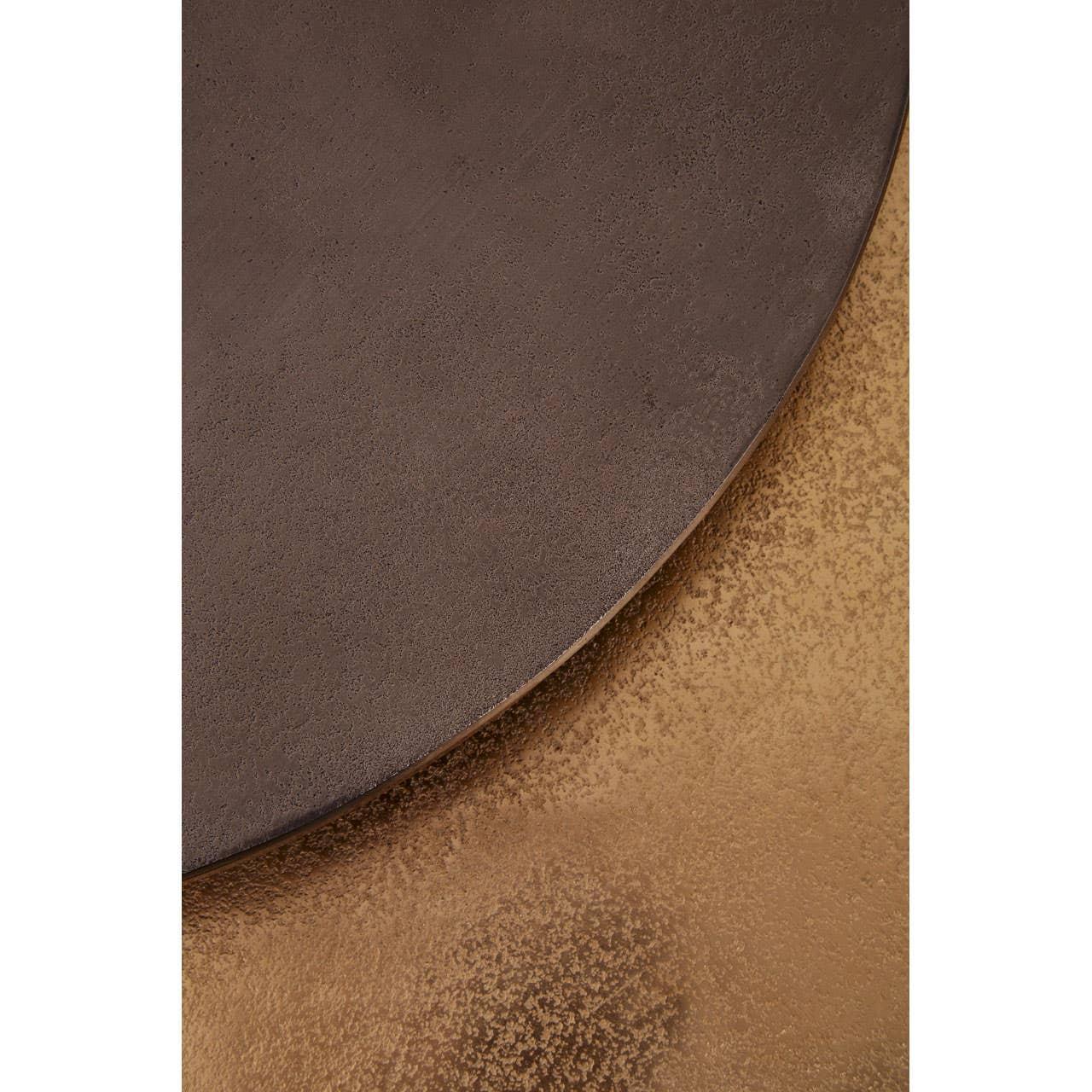 Close up of round bronze coffee table top with textured metallic finish