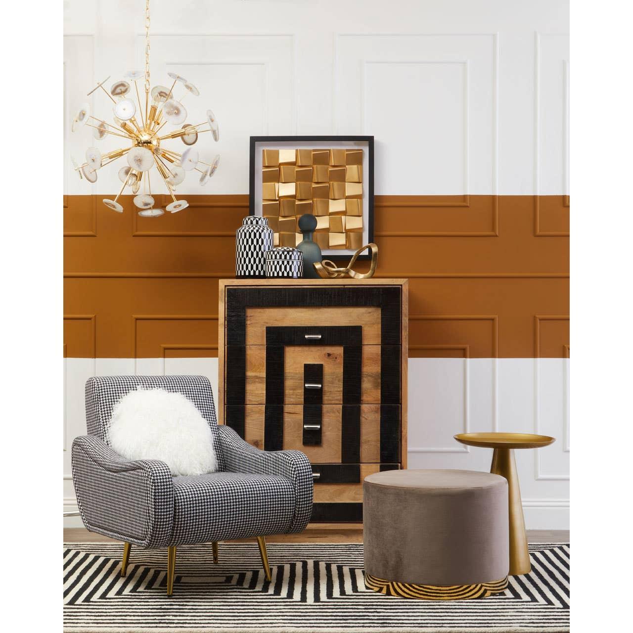 Modern accent chair with geometric sideboard, pouffe and gold side table in stylish living room
