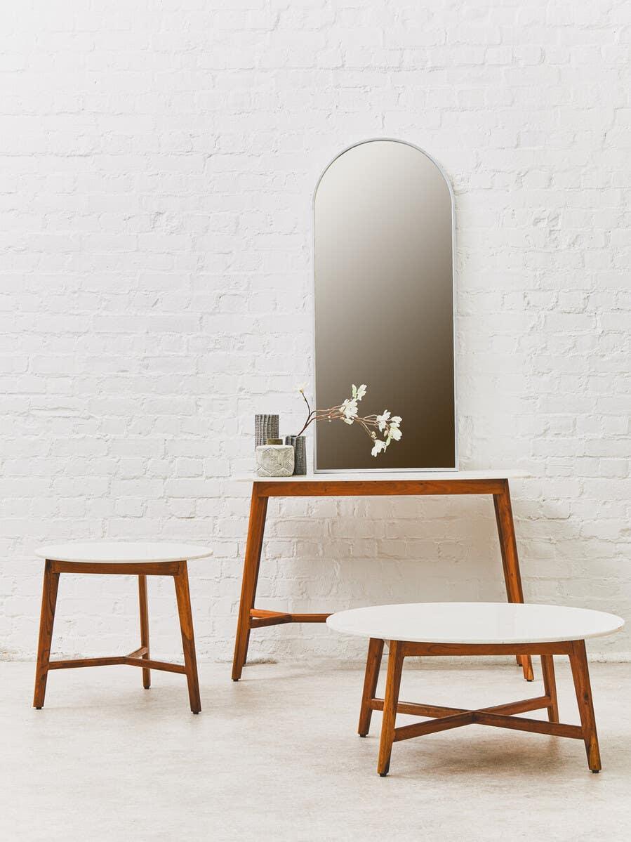 Mid-century modern furniture set with white tabletops and wood legs against white brick wall