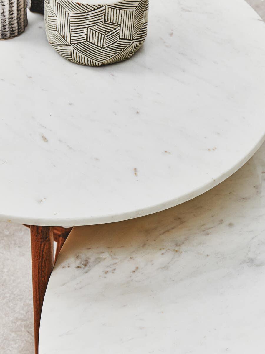 White marble coffee tables with wooden legs and geometric ceramic vase on top