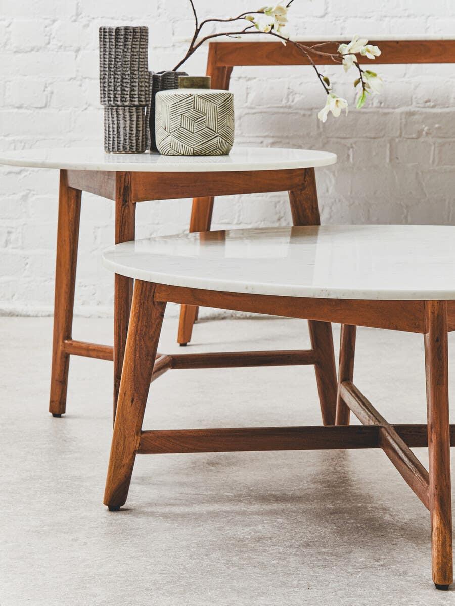 Mid-century modern coffee table with white marble top and wooden legs, decorative vases on top