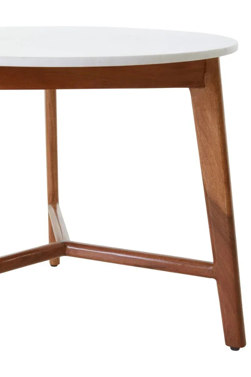 Round coffee table with white top and angled wooden legs, close view of base