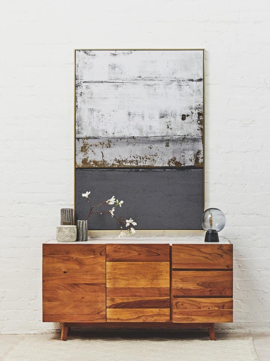 Solid wood sideboard with natural finish, decorative vases, and abstract wall art