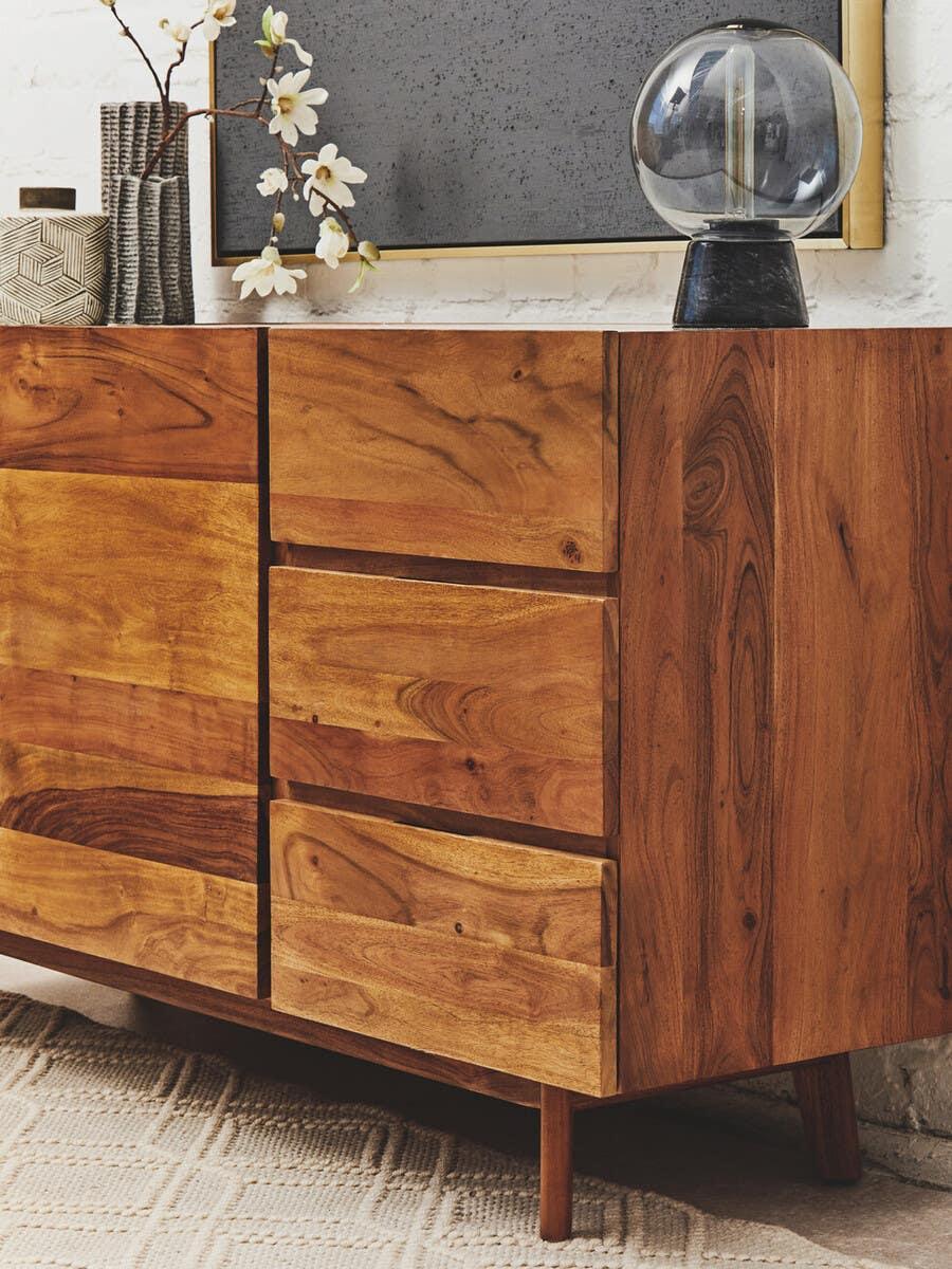 Solid wood sideboard with drawers, decorative vase, and glass lamp on top