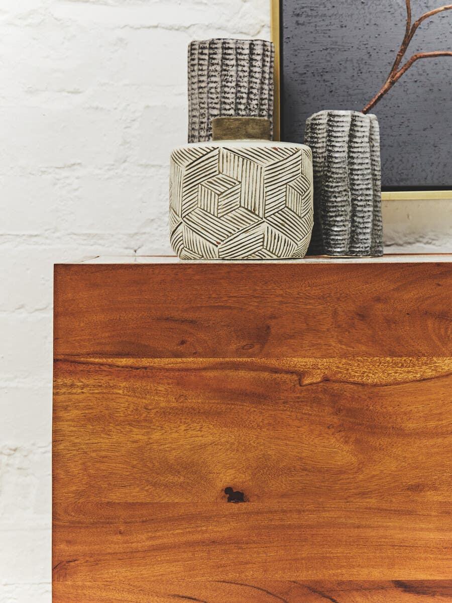Solid wood sideboard with decorative ceramic vases and modern textured artwork on top