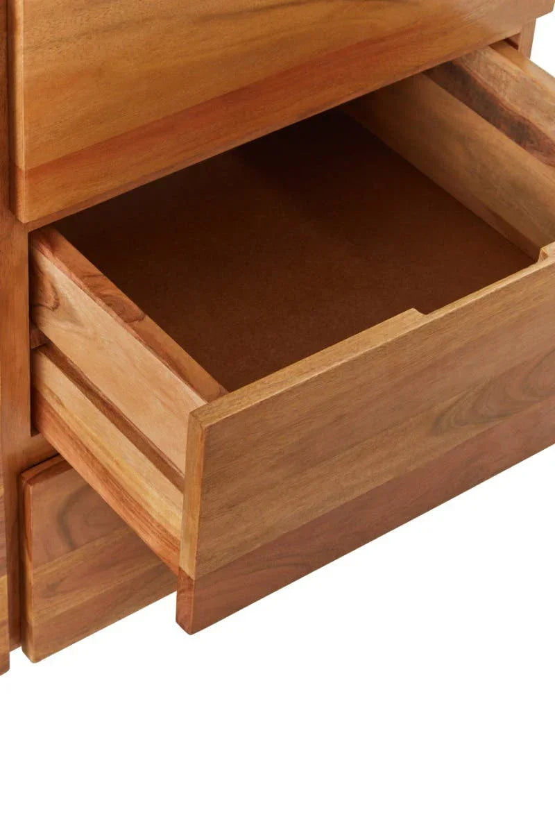 Closeup of wooden chest of drawers with open storage drawer, showing natural wood grain