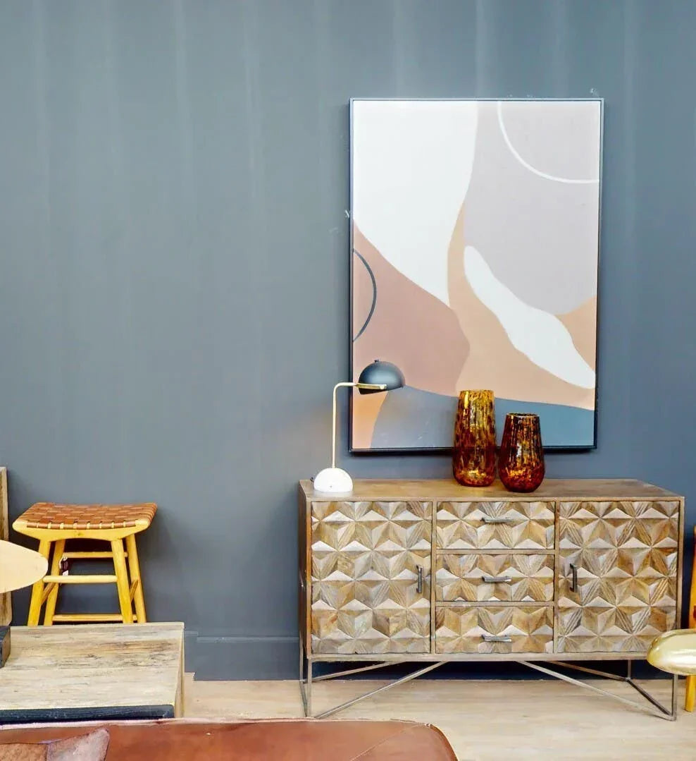 Geometric wood sideboard with drawers, decorative vases, lamp and abstract wall art