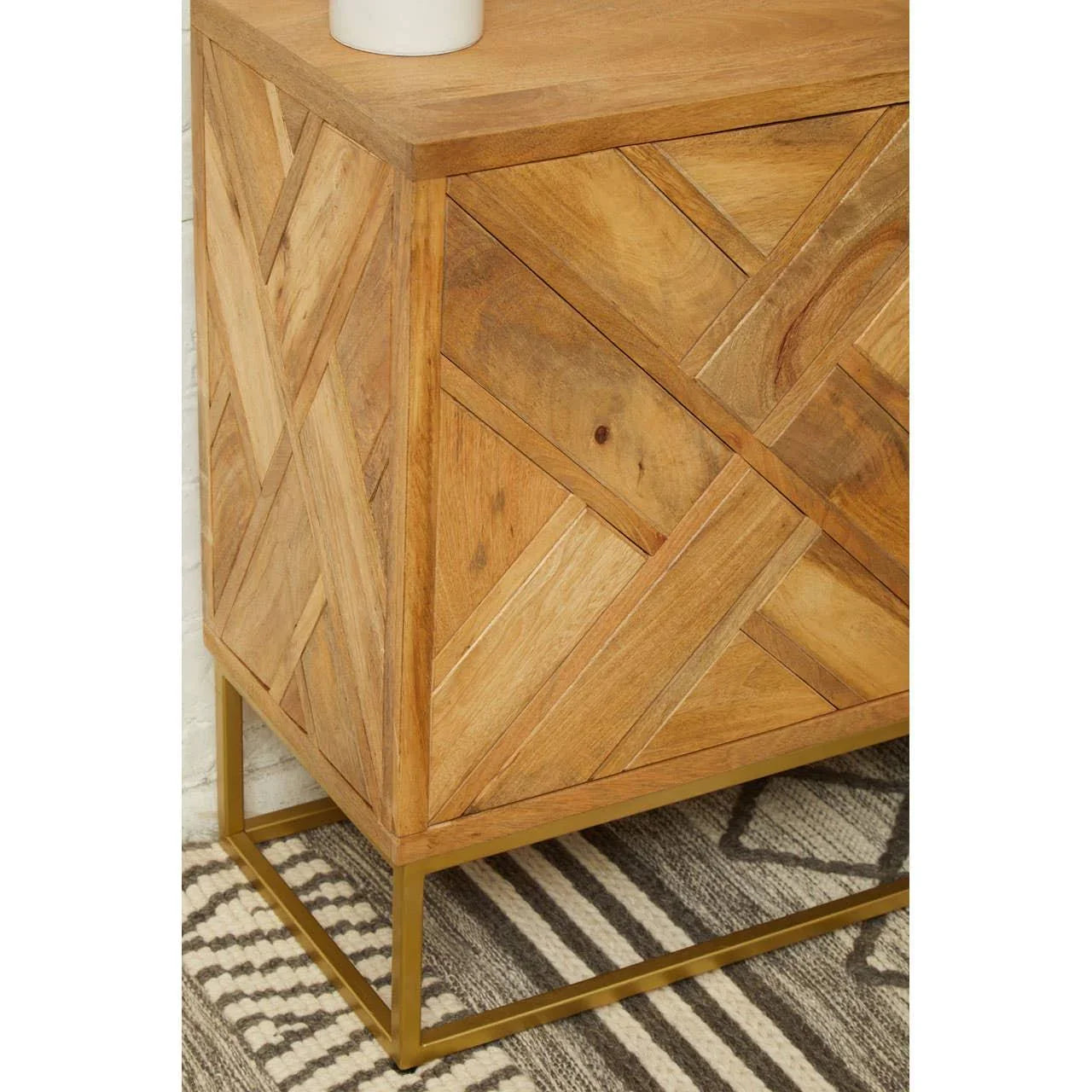 Wooden sideboard with geometric pattern and gold metal base on patterned rug