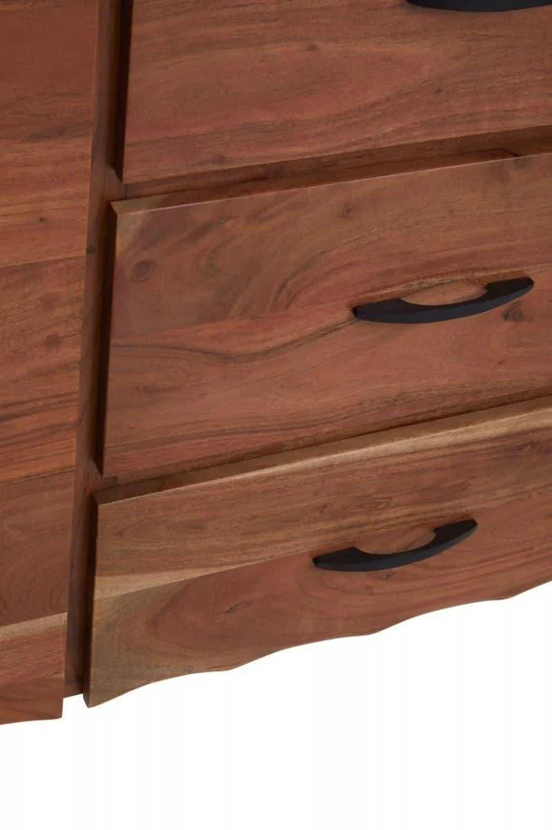 Close-up of wooden chest of drawers with black metal handles and natural grain finish