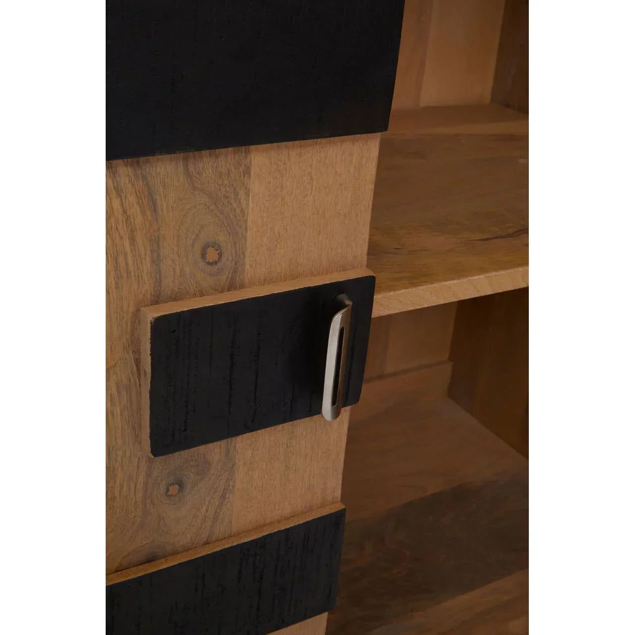 Closeup of wooden cabinet door with black panels and silver handle, showing internal shelf