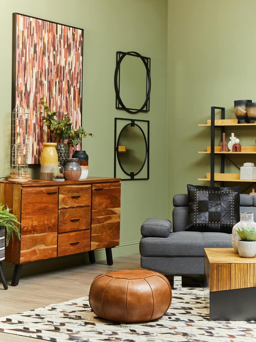 Modern living room with grey sofa, wood sideboard, leather pouffe and geometric decor