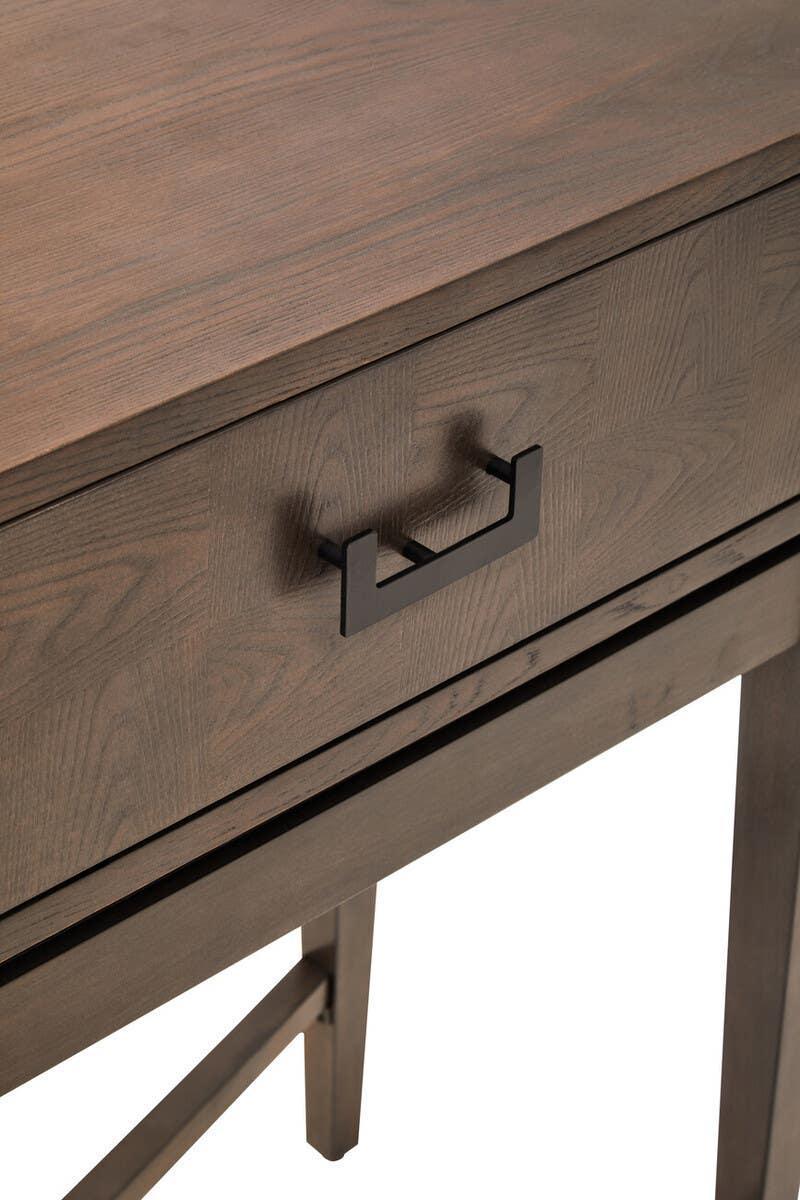 Dark wood desk with black metal drawer handle and visible grain pattern
