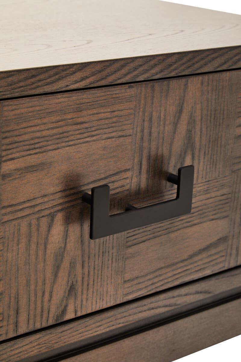 Closeup of wood drawer front with black metal handle and textured grain pattern