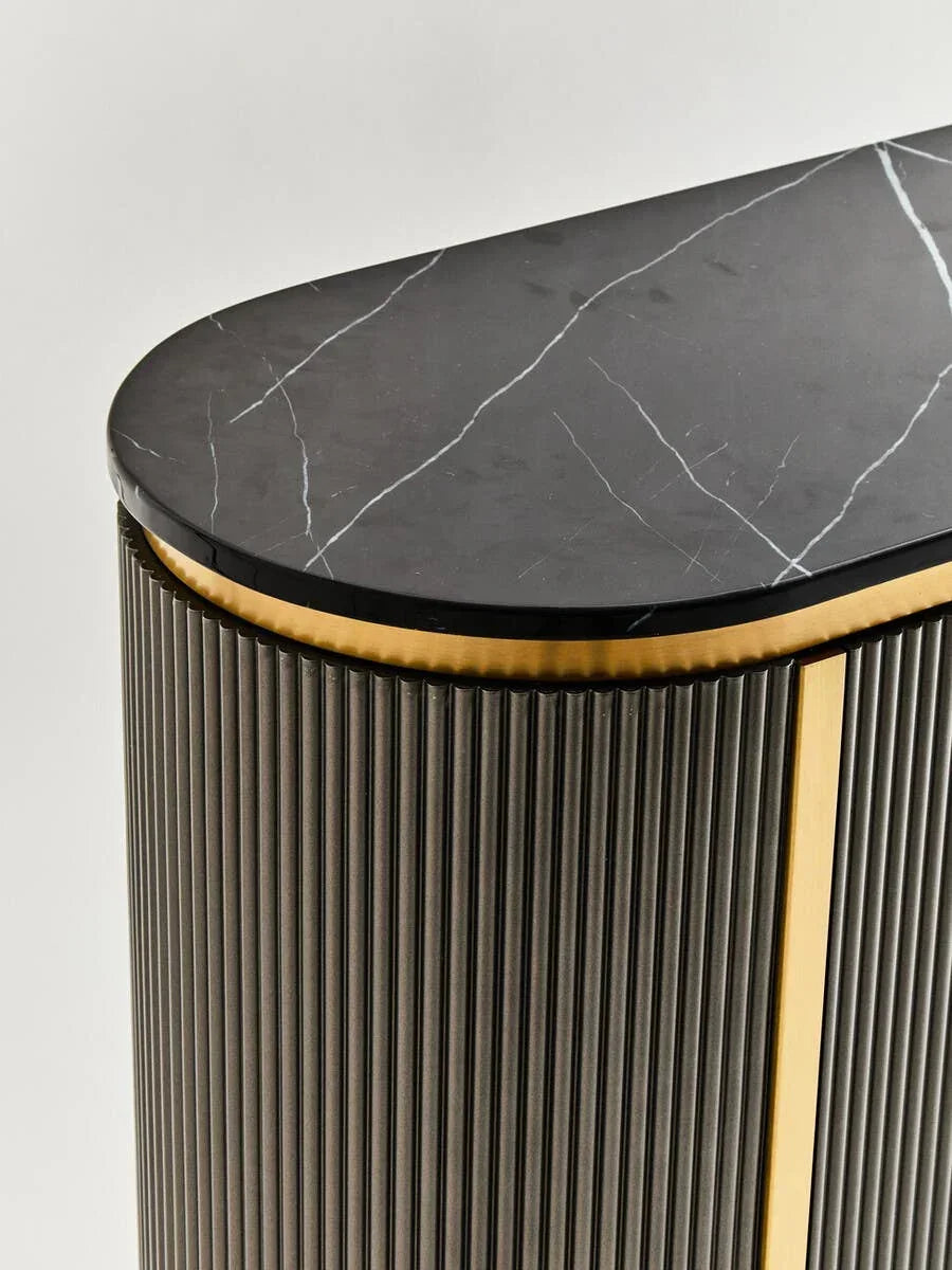 Black marble console table with gold trim and vertical ribbed detailing, close-up corner view