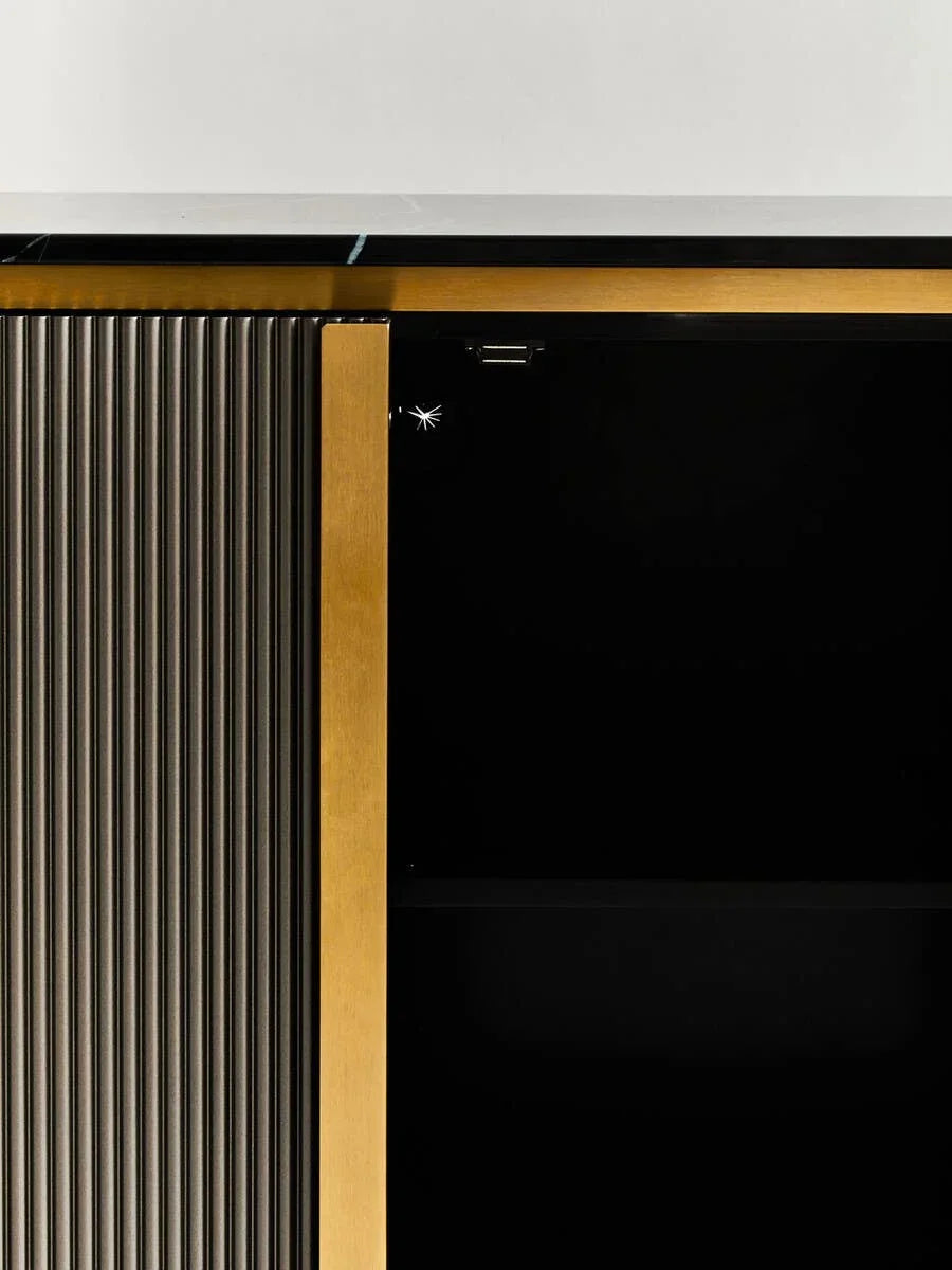 Close-up of modern sideboard with black glass top, gold trim and vertical ribbed panel
