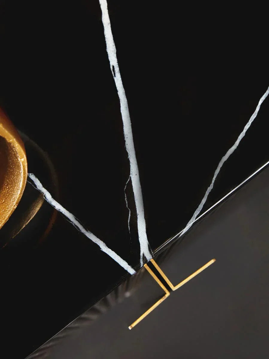 Black marble coffee table corner with gold metal leg and white veining detail