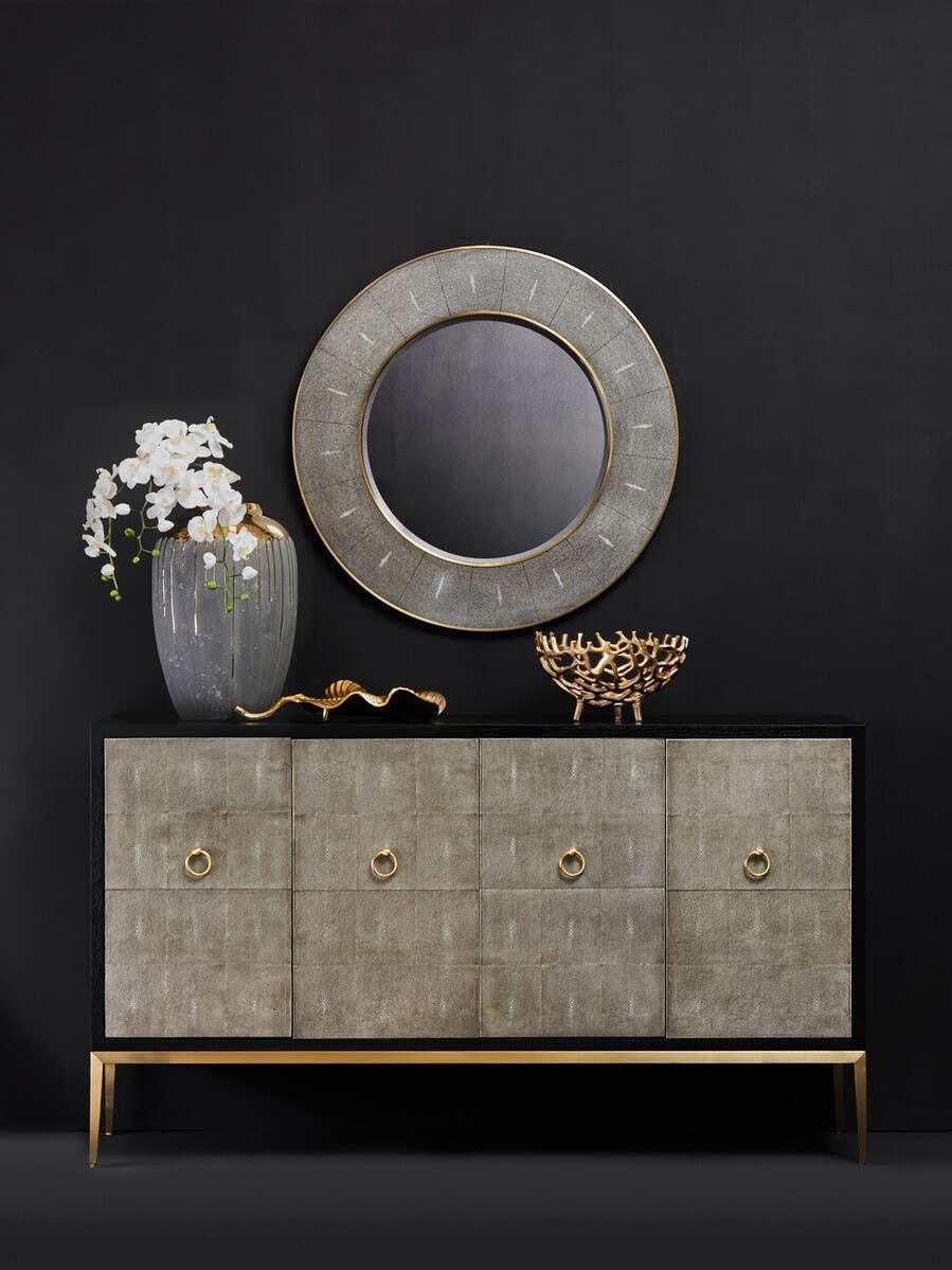 Modern sideboard with grey textured doors, gold legs, and matching round wall mirror