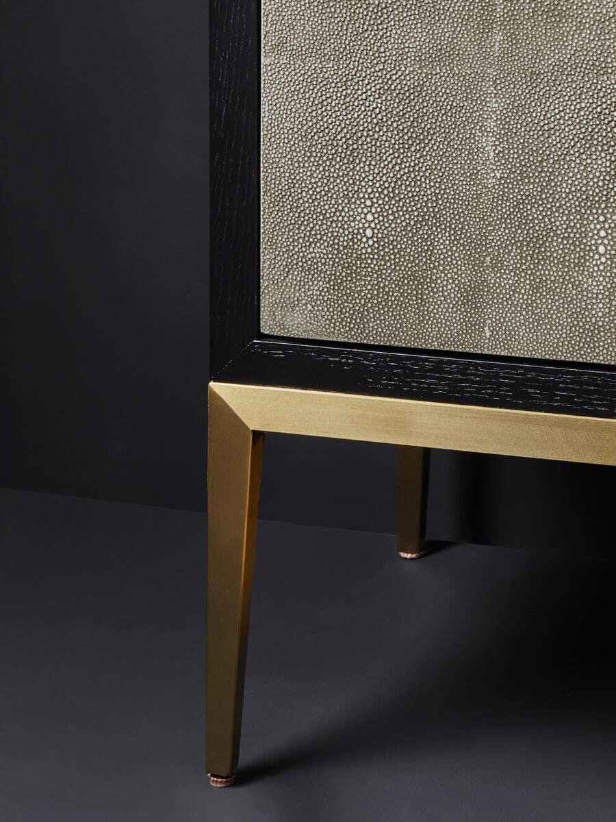Gold metal leg and textured panel detail on modern sideboard cabinet