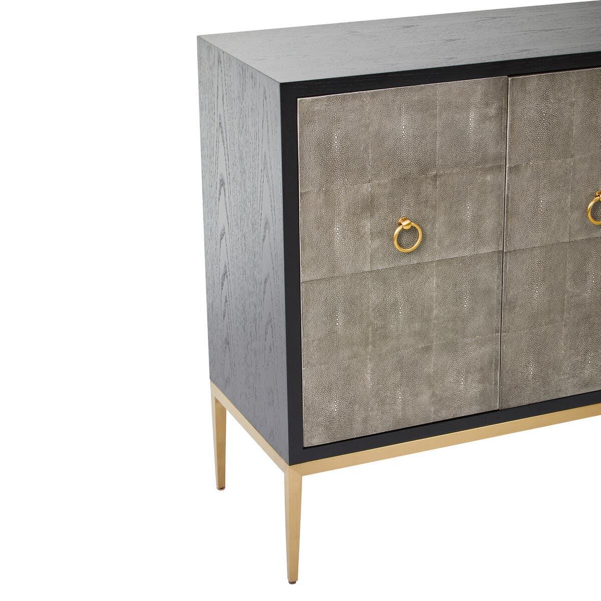 Grey two door sideboard with gold metal legs and ring handles, partial front angle view