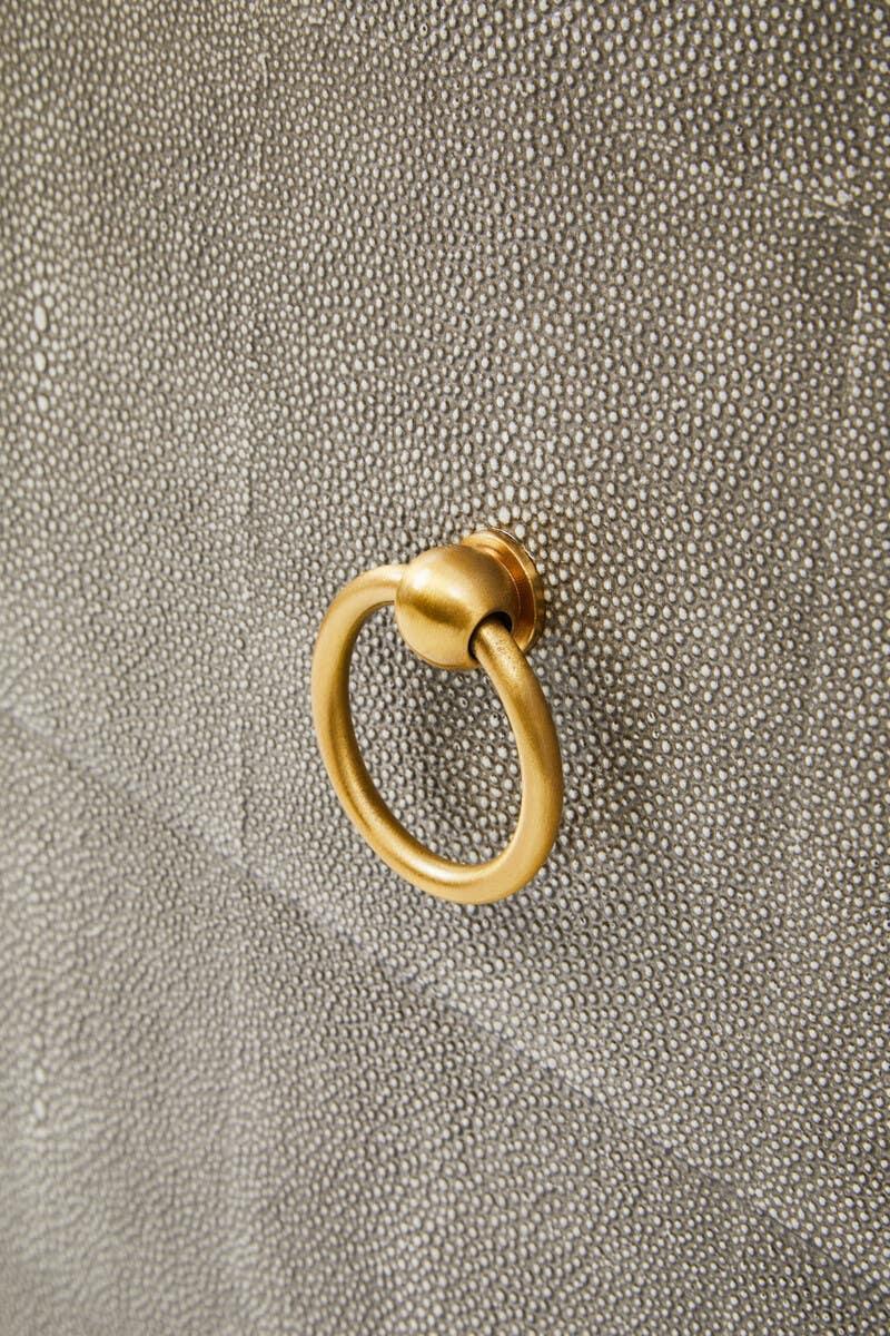 Textured fabric furniture panel with gold metal ring handle detail