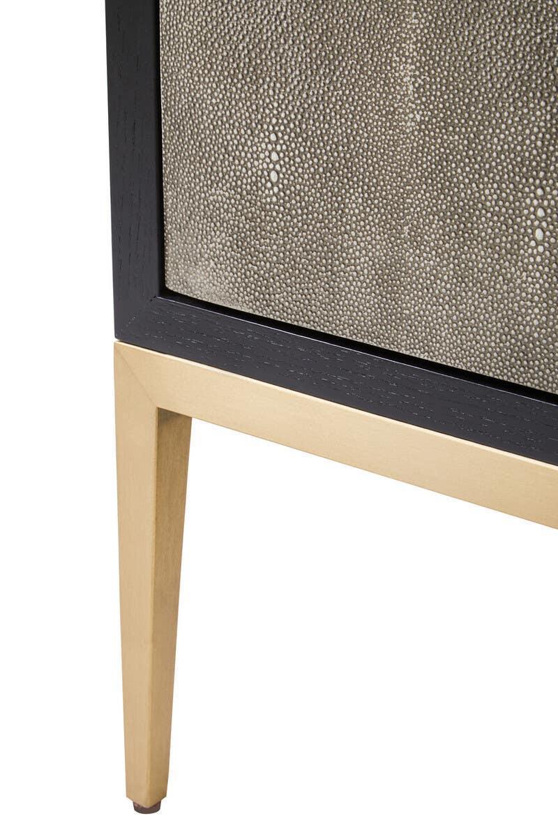 Textured cabinet with black trim and gold leg close-up