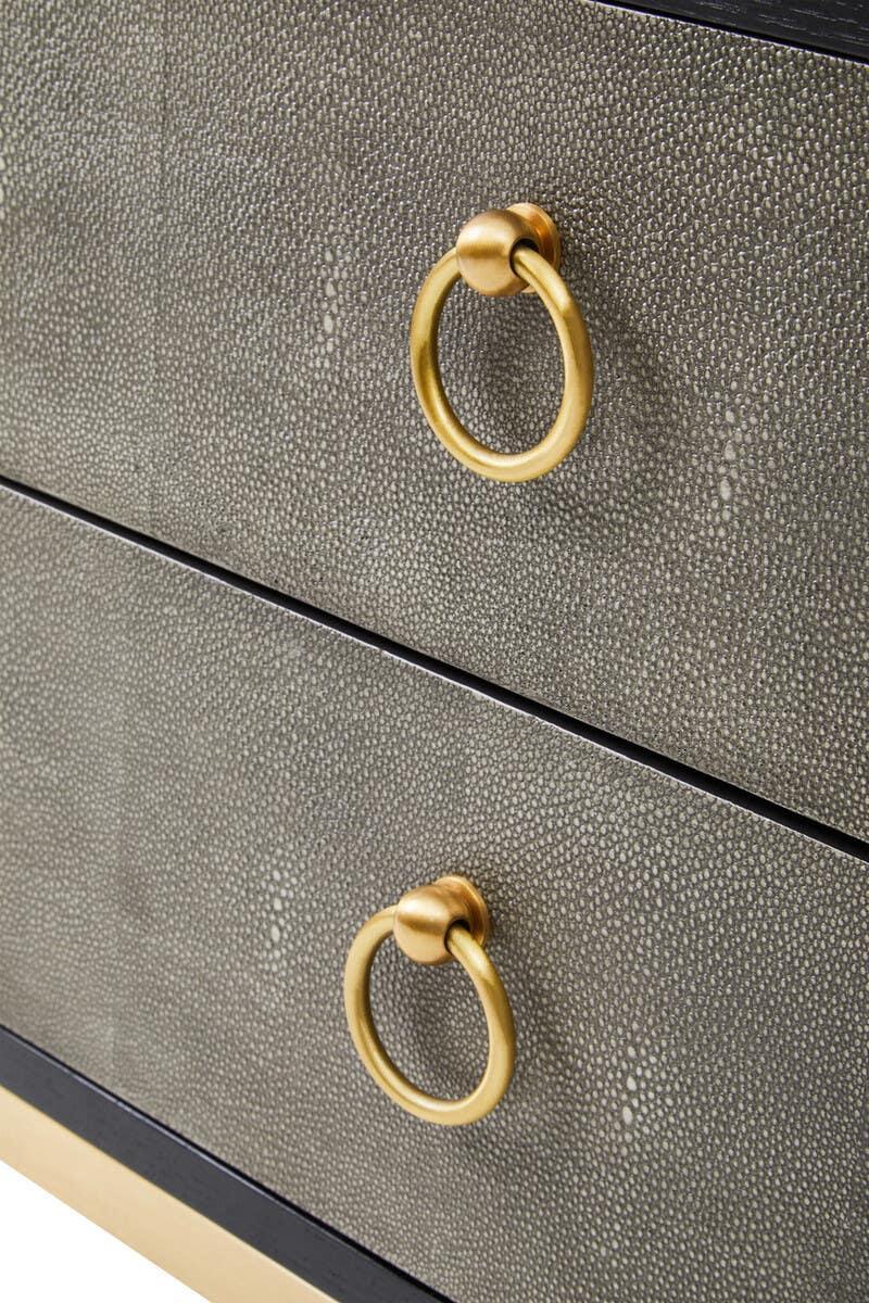 Close up of textured drawer fronts with gold ring handles on a modern chest of drawers