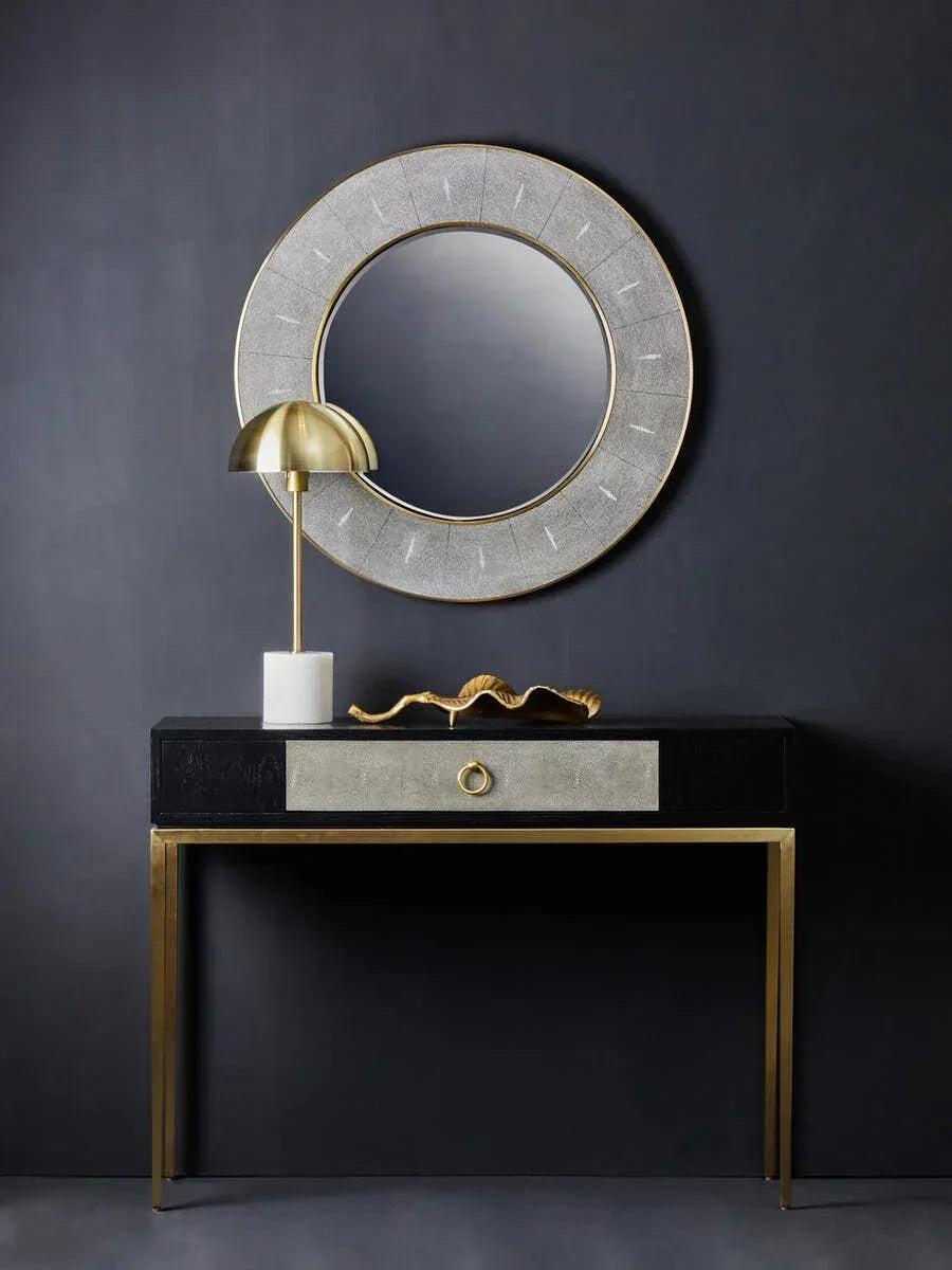Gold leg console table with black top, silver drawer, round wall mirror and lamp