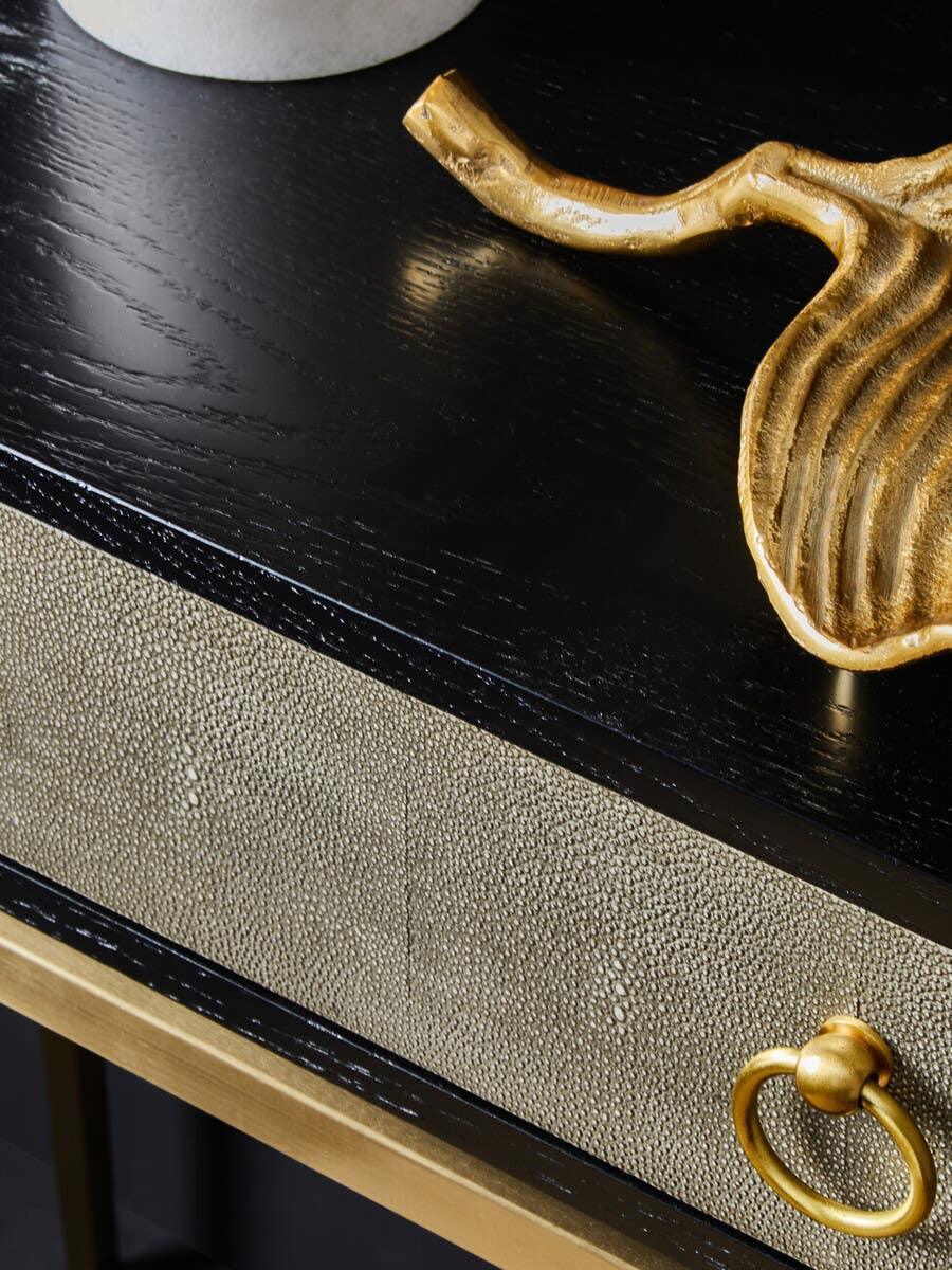 Black console table with textured beige drawer and gold ring handle detail