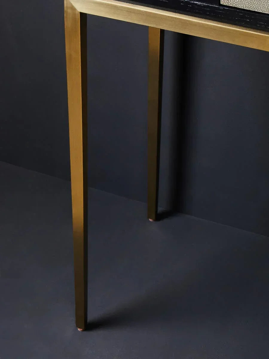 Gold metal table legs with clean lines against a dark background