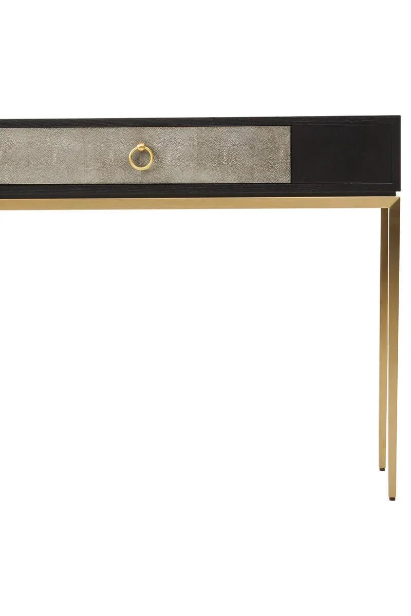 Modern console table with black frame, gold metal legs, and single textured drawer